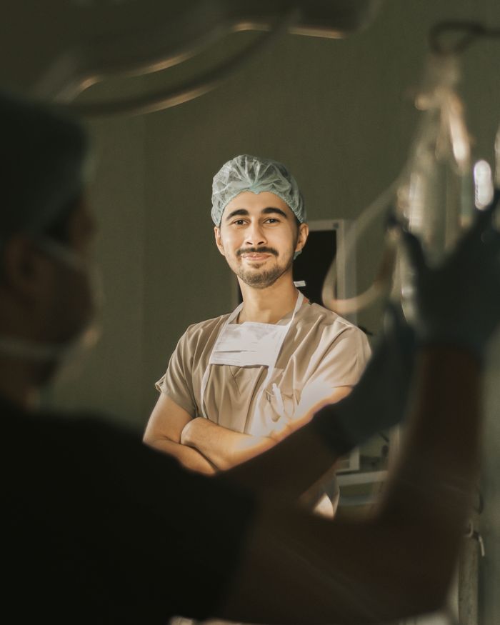 A confident surgeon in scrubs, smiling in an operation room, highlighting professionalism.